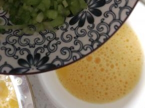 蛋液过筛导入耐热的小碗内，加入芹菜末