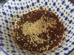 将熟芝麻放入刚刚烫好的辣椒油里