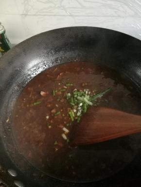 将香干倒入锅内，使酱均匀附着于上，往锅内加入少许水，熬制酱，出锅前加入葱末