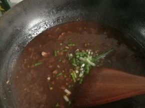 将香干倒入锅内，使酱均匀附着于上，往锅内加入少许水，熬制酱，出锅前加入葱末