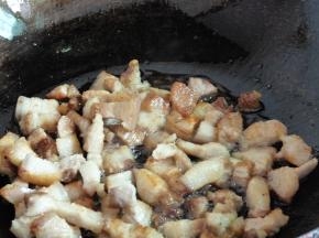 水开五花肉变色捞出，用热水清洗干净肉上的浮沫（以免肉受冷不再软儒）。焯水的锅洗好，重新烧一锅热水备用。另起炒锅下少许油，中小火将五花肉煎至微黄后捞起，把油留在锅里。