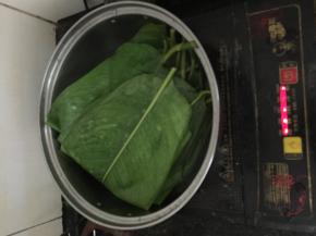准备好五花肉，切成厚2-3cm、巴掌长的长方形，下少许料酒、适量酱油、腐乳、蚝油腌制半天。准备糯米，糯米温水泡1小时后，加入适量油、盐捞匀。将处理好的绿豆芯也加入适量油、盐捞匀。准备好粽叶（大的小的都可以，新手包小的好上手），将粽叶洗净，下凉水稍微煮至变色且弯折叶片不会脆断（韧性变强）时，关火盛出沥干
