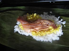 一手托住叶子下方，一手往叶子中心放一层糯米（注意两边留些许区域），再放一层绿豆，随后放上五花肉，再盖上一层绿豆，最后再盖上一层糯米