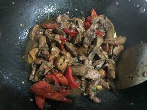 放入辣椒，大火翻炒至稍微软塌后，将鸡肝倒入锅中翻炒几下。