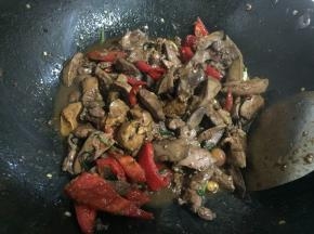 放入辣椒，大火翻炒至稍微软塌后，将鸡肝倒入锅中翻炒几下。