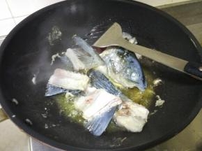 炒锅倒入少量油，烧热后加花椒，蒜，姜，泡椒及木姜子炒香，炒香后加入鱼骨和鱼头煎一分钟