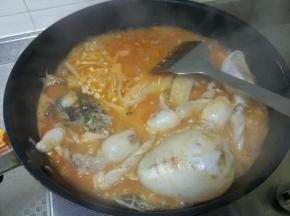 加入凯里红酸汤，继续翻煎1分钟，加入水，水沸腾后，加入少许白糖、及事先准备好的宽粉，金针菇