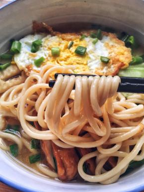 5、	倒入开水，放两勺生抽，至水煮沸后放入面条盖上锅盖煮5分钟。关火，装盘。