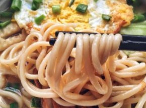 5、	倒入开水，放两勺生抽，至水煮沸后放入面条盖上锅盖煮5分钟。关火，装盘。