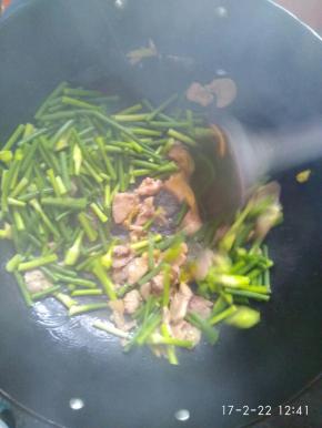 加入蒜苔大火翻炒，加入适量的盐，十三香等调味品，转小火继续翻炒。