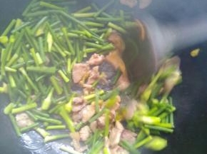 加入蒜苔大火翻炒，加入适量的盐，十三香等调味品，转小火继续翻炒。