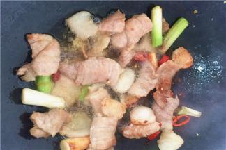 5、放入肉片，中火炒至其变金黄色