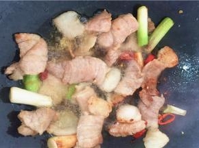 5、放入肉片，中火炒至其变金黄色