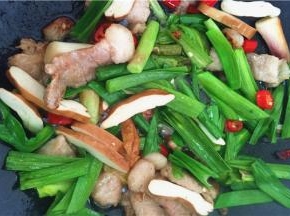 6、放入大蒜叶、香干一起爆炒，放入黄酒、盐