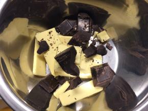 2、黄油、巧克力切成小块，放入同一个碗中，隔水加热并不断搅拌，直到黄油和巧克力都融化成液态，取出冷却备用。
