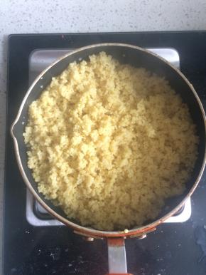 3、盖上锅盖，小火将小米的水分煮干，最后还剩余少量水分时可以打开锅盖用勺子不断翻动小米，避免糊锅。煮好后打开锅盖放通风处晾凉。