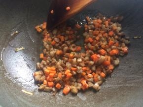 6、下入胡萝卜丁继续翻炒两分钟，加入食盐、老抽调味。