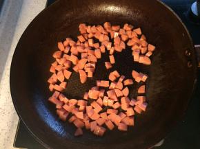 3、平底锅倒一点底油烧热，下入火腿肠翻炒一分钟。