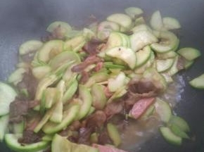 放入火腿翻炒片刻，加入味精，葱花，即可出锅。