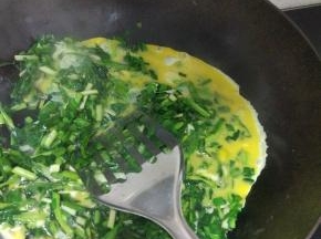 锅内放油烧热，加入韭菜，放入适量的盐，韭菜炒软倒入蛋液