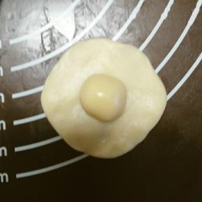 松弛好后的油皮分成12份，取其中一份按平成圆形，包上油酥，收口