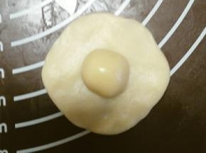 松弛好后的油皮分成12份，取其中一份按平成圆形，包上油酥，收口