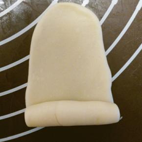 用擀面杖擀成牛舌状，卷起，盖上保鲜膜，再盖上湿毛巾，松弛15分钟