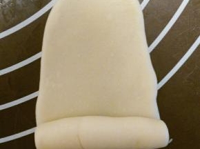 用擀面杖擀成牛舌状，卷起，盖上保鲜膜，再盖上湿毛巾，松弛15分钟