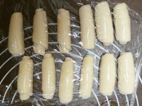 松弛好后，再次用擀面杖擀成牛舌状，卷起，继续盖上保鲜膜和湿毛巾，松弛15分钟