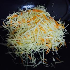 油锅加热，先倒入胡萝卜丝翻炒，再加入土豆丝翻炒