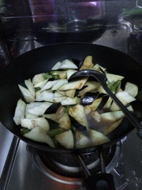 4.	锅内加入适量油，先把茄子放入锅中炒一分钟左右随后放入土豆和豆角。