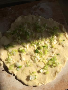 3.	把葱切成碎状，放入擀好的片上，加入适量油。