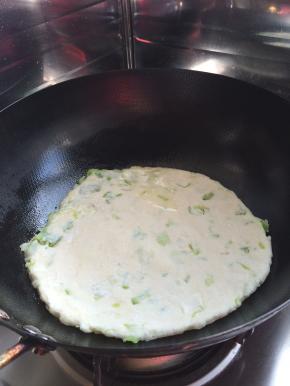 6.	锅内加入适量油，摇晃是油均匀。把擀好的饼放入锅中。