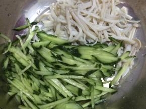 4.	把黄瓜切成丝状，放入海鲜菇中。