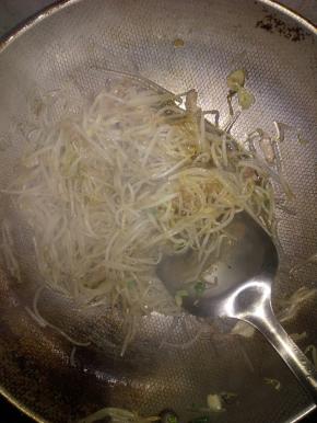 把豆芽和粉放入锅里翻妙，同时放入酱油，陈醋，盐调味品。