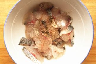 腌制鱼肉，用两只碗，一只碗腌鱼片，另一只腌鱼头、鱼骨，每只碗分别放入1勺黄酒、1勺盐、半勺胡椒粉