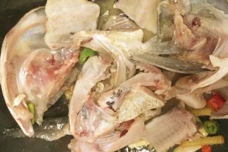 放入鱼头、鱼骨炒制