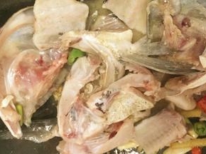 放入鱼头、鱼骨炒制