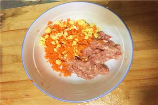 根据自己的喜好，把刚刚切好的胡萝卜、玉米末和猪肉一起搅拌均匀