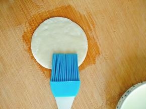 先刷一点油在案板上，防止粘连，然后取下一片饺子皮，在表面刷一层薄薄的油