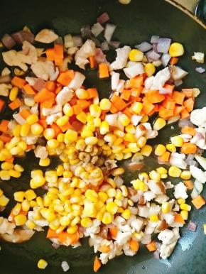 .放入其他配菜丁一起翻炒，放入黑胡椒，炒匀后放入白砂糖