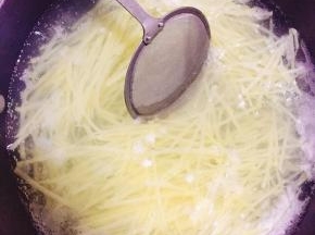 土豆擦丝入热水锅内焯熟。