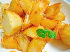 糖熬制琥珀色即可，放入土豆迅速搅拌，每颗土豆均裹满汤汁，装盘，迅速拔丝