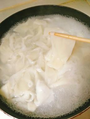 水沸后放入扯好的饺子皮，煮熟