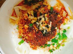 煮好后捞出，表面放上准配好的配料，葱花、姜蒜末、花椒粉、盐、鸡精、辣椒面、芝麻