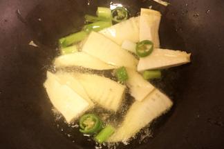 起火，先放入笋、辣椒、大蒜煸炒