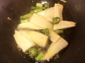 起火，先放入笋、辣椒、大蒜煸炒