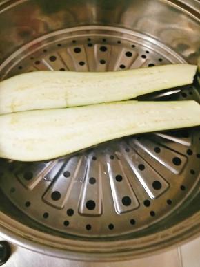 将茄子从中间切开，方便蒸，水沸后，放入茄子，大火蒸