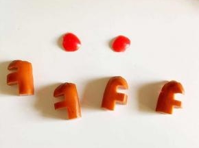 还要做两个方向相反F小火腿，将小番茄头切下来薄薄的一片，准备做麋鹿的鼻子。