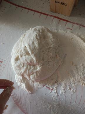 案板上放适量的面粉，面团排气